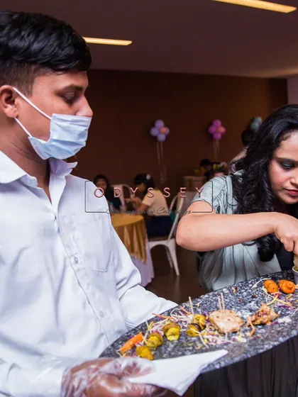 A member of our service staff offering a platter of assorted appetizers to a guest. We pride ourselves on our attentive and professional pass-around service.
