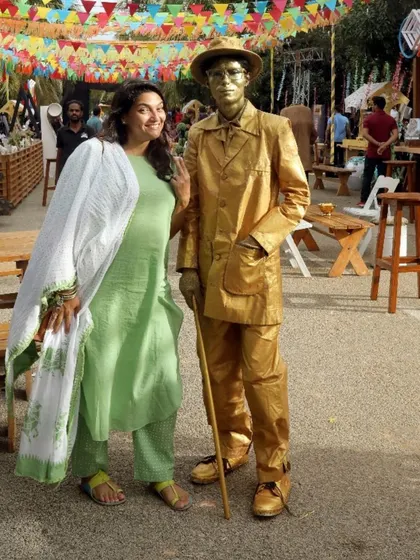 A guest posing with a "living statue" entertainer at a street-fair-themed event. These unique entertainers add an element of surprise and wonder.