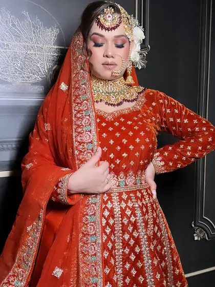 A full view of the burnt orange velvet Anarkali-style lehenga, a warm and rich choice for a winter wedding.