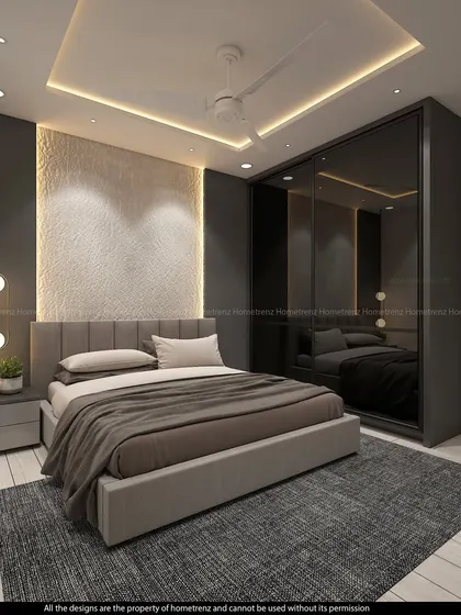 This guest bedroom has a textured accent wall behind the bed, illuminated by spotlights. The dark wardrobe and neutral bedding create a calm, hotel-like feel.