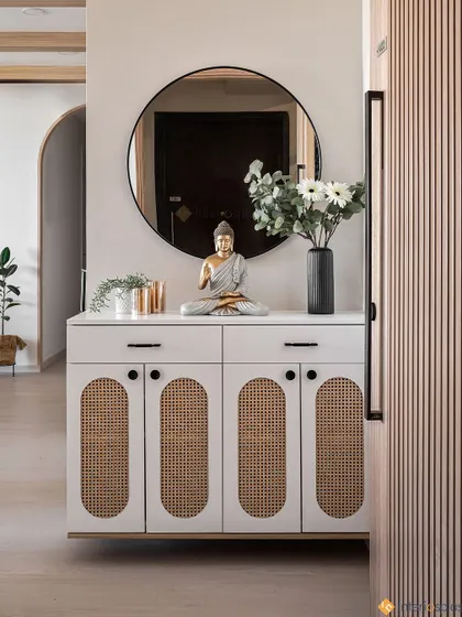 A closer look at this Japandi-style entryway console. The cabinet features woven rattan details, and the Buddha statue and plants create a calm, welcoming vibe.