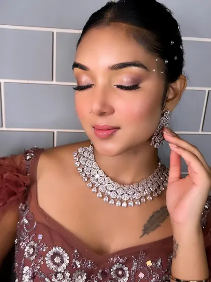 A soft and romantic reception look created by a student. The subtle smokey eye and glowing skin are perfect for an evening event, showcasing their versatility.