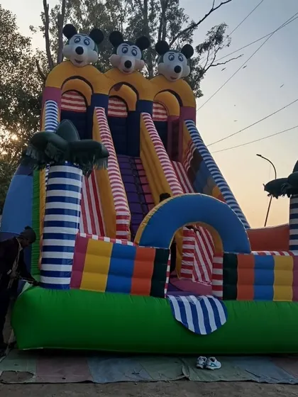 This is our 3-line Mickey Mouse bouncy slide. The striped palm trees and colorful base make it a very attractive option for any party.