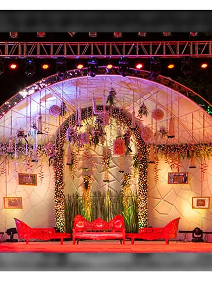 A grand reception stage setup at our open ground. The arched structure and vibrant red seating create a bold and dramatic backdrop, perfect for an evening of celebration.