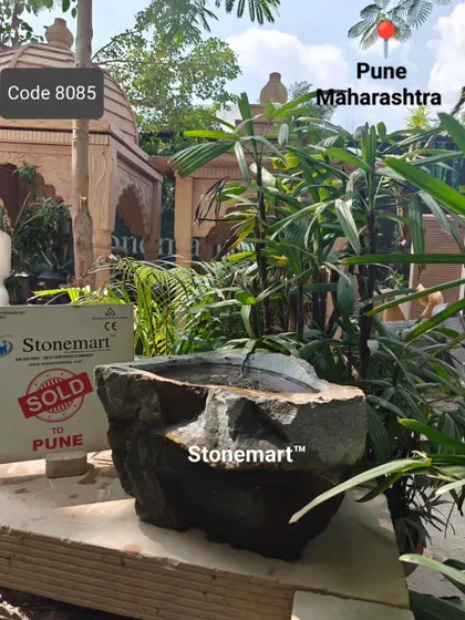 This natural rock bubbler fountain, sold to a client in Pune, is set up in a garden environment. It provides a gentle water source for birds.