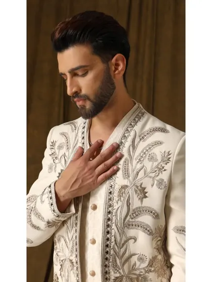 A close-up of the shoulder and lapel of the 'Pragyan' shrug. The detailed cream and gold embroidery, inspired by garden motifs, is clearly visible, demonstrating my commitment to artisanal craftsmanship.