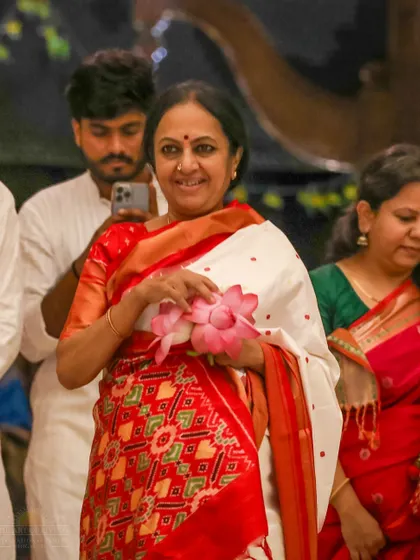 Bhanumathi Narasimhan holds a lotus flower during the VVMVP Foundation Day celebration. The event honors the journey and the vision that has brought smiles to millions.