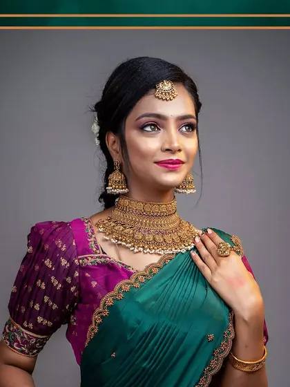 A lovely portrait of a client in a green and purple half saree, showcasing another color combination available for rent.
