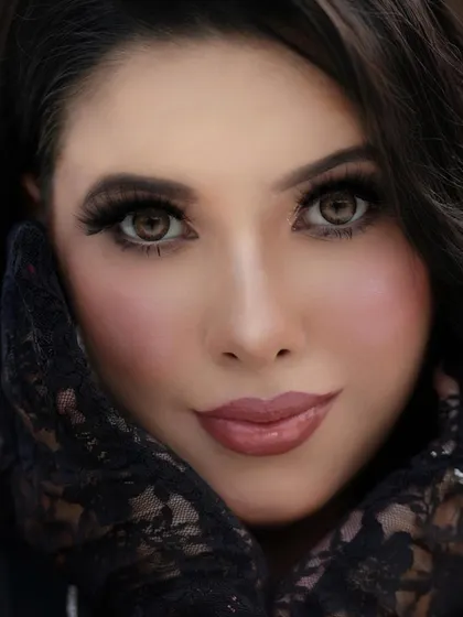 A detailed close-up of the eye makeup for a full glam look. This shot highlights the precise blending, the full lashes, and the soft blush application that creates a sculpted yet soft finish.