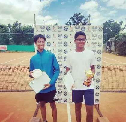 The Boy's Singles winner and runner-up from the AITA TS7 U-14 tournament stand on the winner's podium with their awards.