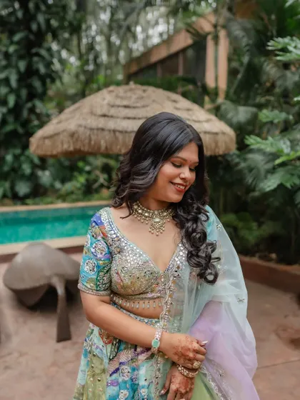 Rachana's fun and stylish look for her Haldi event. The colorful lehenga is paired with soft waves and glowing makeup.