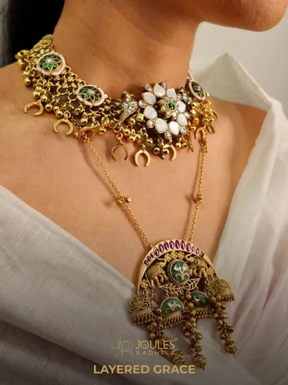 A layered neckpiece that speaks louder than words. This unique piece combines a floral choker with a longer pendant necklace featuring elephant motifs, blending different traditional styles into one cohesive design.