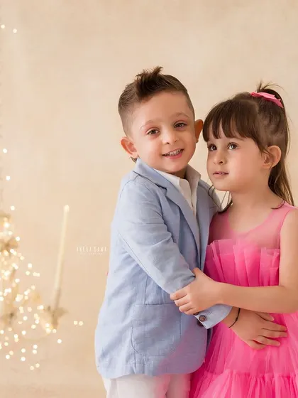 A warm embrace between a brother and sister. The soft, warm lighting and their closeness create an intimate and loving portrait.