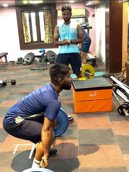 An athlete prepares for a power clean. This starting position is critical for generating force from the ground up, a key component of Olympic weightlifting that I incorporate to build explosive power.