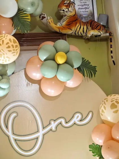 A close-up of a custom balloon flower and a 'One' sign from a jungle-themed party, showing our creative use of balloon's to fit any theme.
