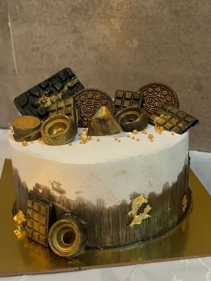 A modern chocolate cake with a black and gold theme. I used a black cocoa brushstroke effect and topped it with gold dusted Oreos and chocolate pieces.
