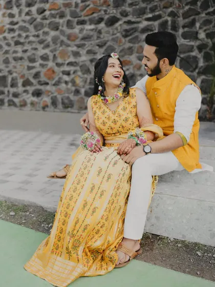 A candid shot of the couple sharing a laugh during their Haldi ceremony. These unposed, joyful moments are what make the best memories.