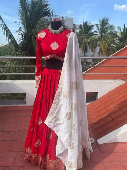 The elegant white dupatta with gold embroidery adds a touch of grace to the outfit.