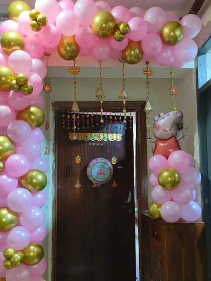 A cute Peppa Pig themed entrance decoration. A pink and gold balloon arch welcomes guests, with a Peppa Pig foil balloon to greet the birthday child.