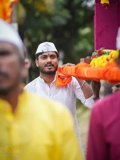 A devotee carries the palki (palanquin) during the Ashadhi Ekadashi procession. This act of service is performed with great joy and devotion.
