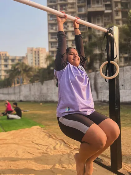 A smile of confidence while working on dead hangs. She is building the fundamental strength needed for more advanced moves.