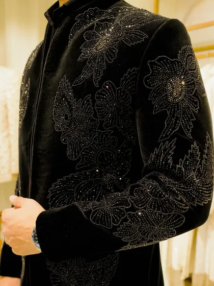 The true value of a bespoke garment is in the details. This is a close-up of the intricate, tonal hand-embroidery on a black velvet jacket, showcasing the level of craftsmanship that goes into each piece.