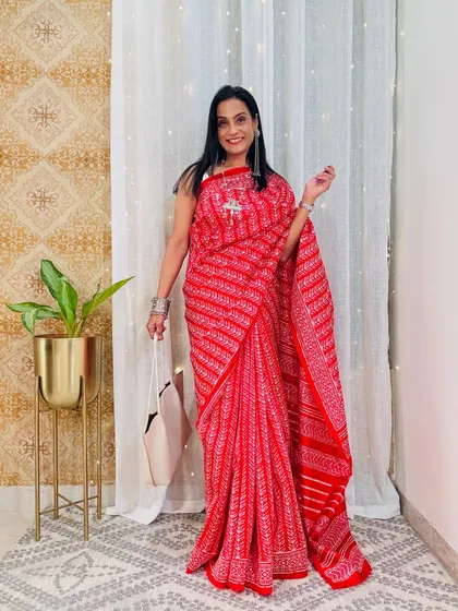 A vibrant red printed saree that is perfect for making a statement at work. The print is traditional yet stylish, and the color is bold and confident.