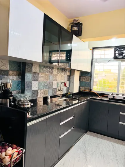 A wider view of the kitchen, showing the practical placement of the sink and stove, with plenty of room for appliances.