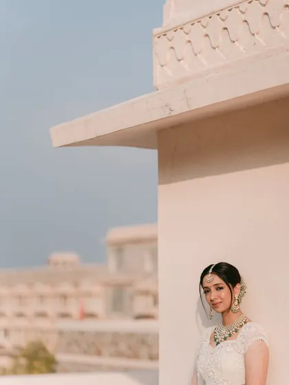 A beautifully composed portrait using the architecture to frame the bride. The clean lines and soft colors create a modern yet classic feel.