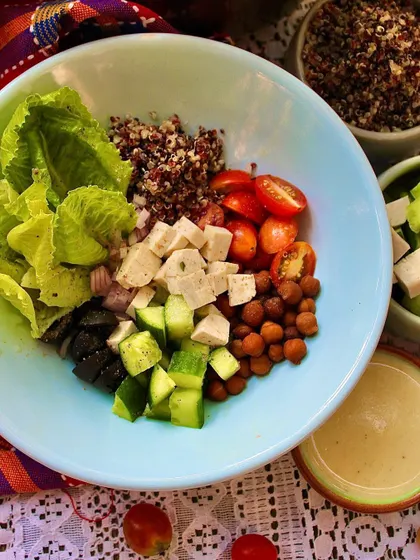 Our High Protein Salad Bowl, deconstructed to show all the wonderful ingredients. It includes organic quinoa, savory black chana, silken tofu, cucumber, and tomatoes.