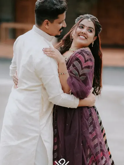 A joyful and candid moment from an engagement shoot, with the couple sharing a laugh and an embrace.