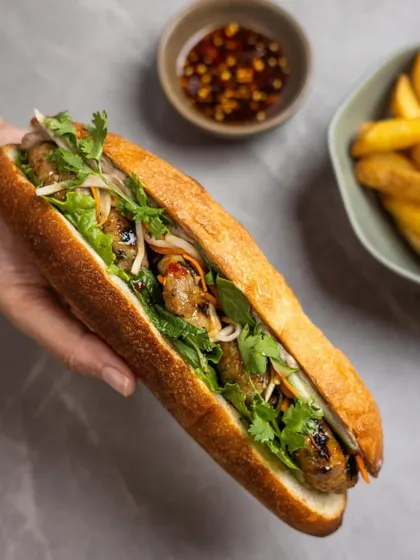 Our Bánh Mì, inspired by a trip to Vietnam. It’s a lesson in balance, with grilled pork patties, chicken liver pâté, fresh herbs, and chili caramel in a crisp baguette.