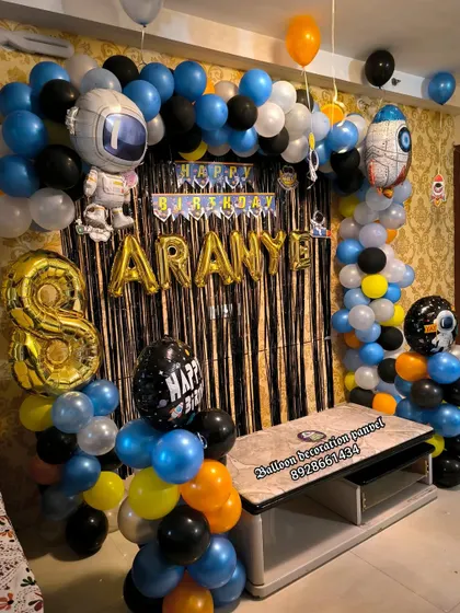 An out-of-this-world Universe theme for an 8th birthday. The balloon arch features astronaut and rocket ship foil balloons, creating a space adventure for the birthday boy.