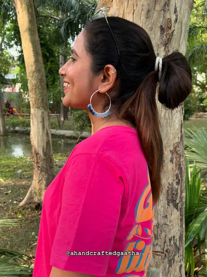 A customer styling the denim blue 'Naazakat' hoops with a bright pink tee. This shows how versatile they are for color-blocking and creating a fun, casual look.