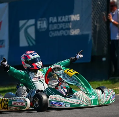 The pure emotion of victory. One of our drivers celebrates crossing the finish line to win a race in the FIA Karting European Championship, a testament to our international competitiveness.