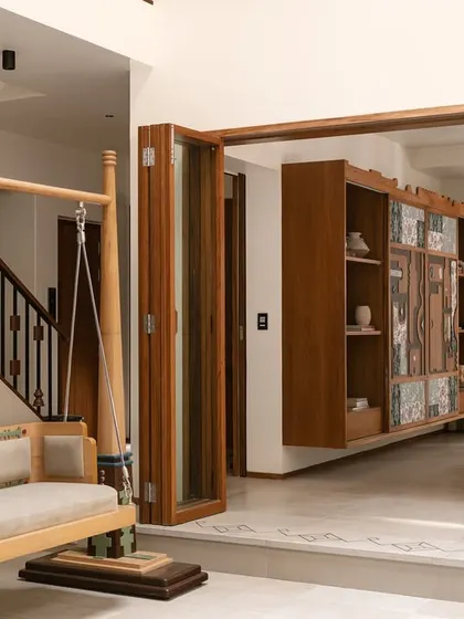 The central courtyard of Kolam Pop, where a traditional Oonjal (swing) sits beside the living room. The space is designed to be a bridge between the different areas of the home, grounded in cultural heritage.