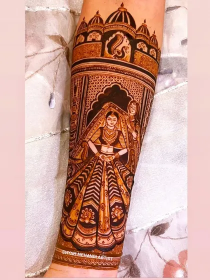 A full-figure portrait of a bride in her stunning lehenga, meticulously detailed on the forearm.