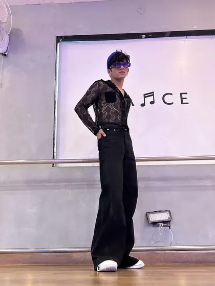 A stylish look in a studio, with flared pants and a sheer shirt. This retro-inspired outfit is great for certain music styles.