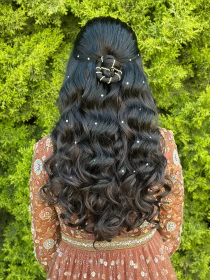 The full view of the pearl-scattered curly half-updo. It's a dreamy and elegant hairstyle perfect for any special occasion.
