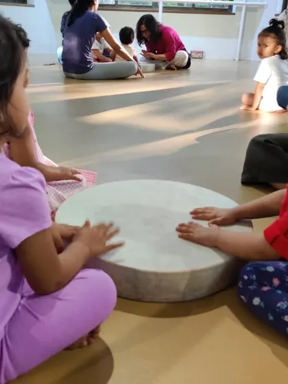 Two friends sharing a moment at the gathering drum. This is a beautiful example of how music helps children connect, cooperate, and learn to play together.