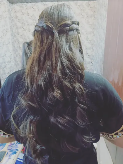 A half-up style with two crossing braids and soft waves. This is a versatile look that adds a touch of bohemian flair to any ethnic outfit.