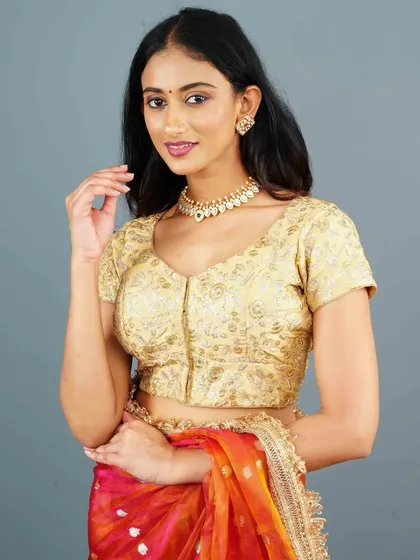 A fully embroidered gold blouse is accessorized with a matching choker and earrings. This creates a rich, monochromatic look that is pure elegance.