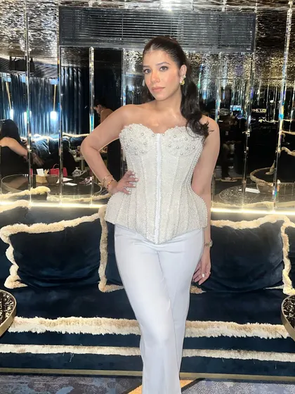 A confident and chic pose. The makeup is designed to look stunning in the low, ambient lighting of a fancy restaurant or bar.