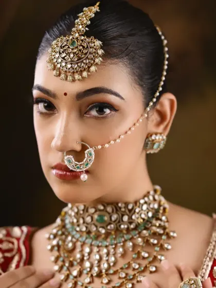 A full view of the intricate jewelry and the rich red embroidered blouse, part of a student's portfolio.