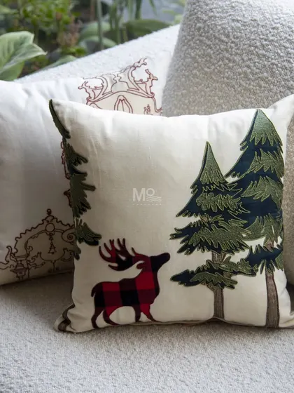 Our festive Christmas cushion, featuring a charming reindeer with a plaid pattern alongside embroidered pine trees. A perfect way to bring holiday cheer to your home.
