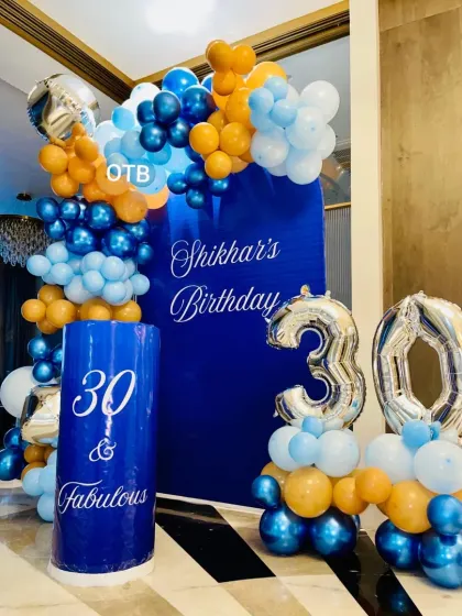 A detailed shot of the 30th birthday setup, showing the combination of the personalized plinth and large foil numbers.