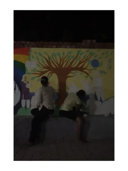 Painting into the night to bring a community wall to life. This image shows two of us sitting and working on a mural under the moonlight. These projects are often a labor of love, filled with conversations and shared effort that continues long after the sun goes down.