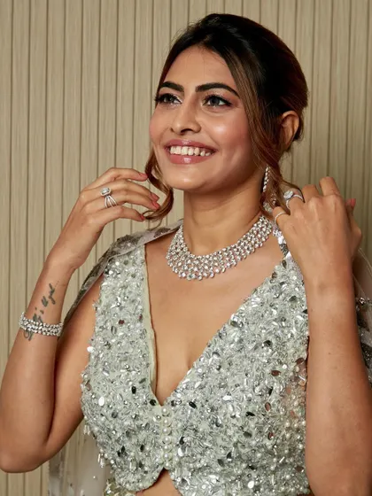 Adjusting her jewelry, this client looks absolutely radiant. The all-over shimmer of her outfit is balanced with a glowing, polished makeup look.