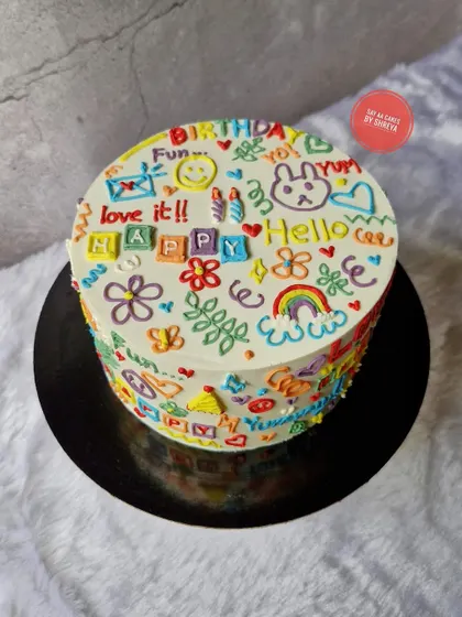 Where creativity meets cake. This playful doodle cake is covered in colorful, hand-piped drawings and messages, making it a fun and unique centerpiece for any celebration. It's a Lotus Biscoff cake inside.