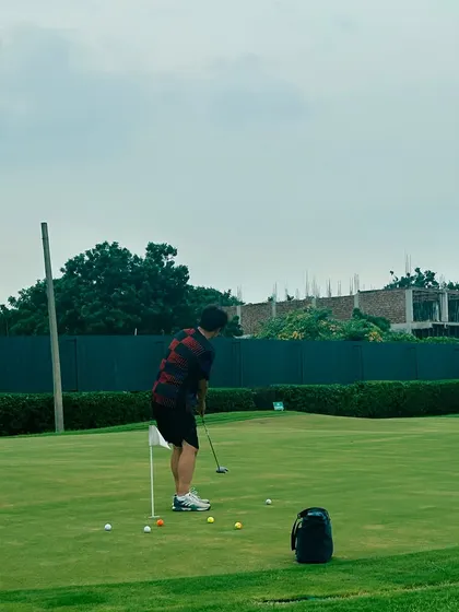 A lone golfer practices his putting as the day winds down. The range can be a place for quiet focus and personal improvement.